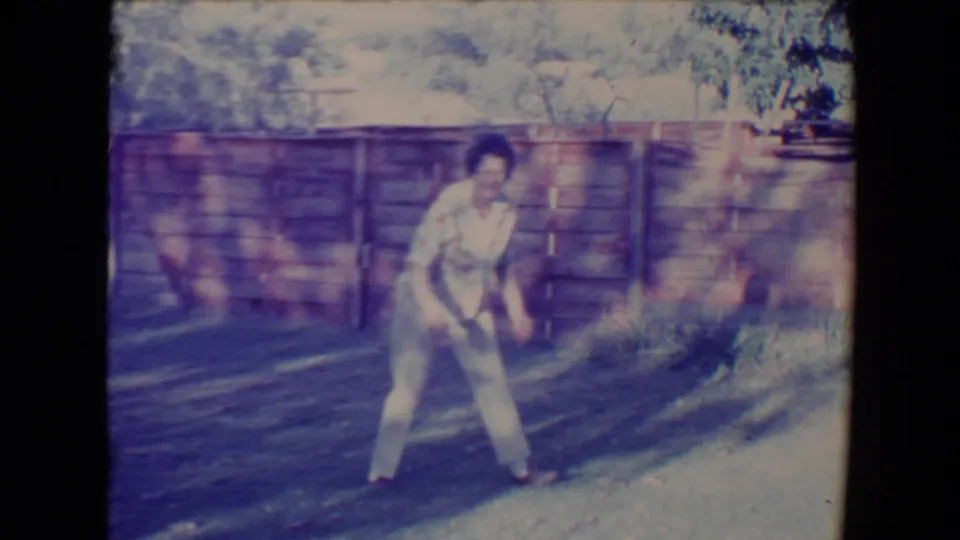 In the 1967 backyard scene, the woman stands on the grass as if preparing to throw during a game with the dog.