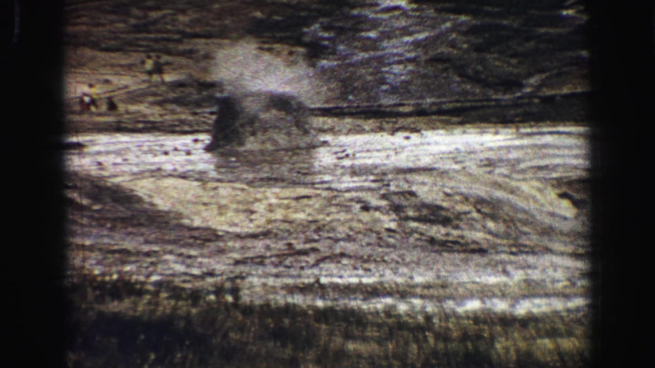 Steam rising from a small vent in pale rocky terrain.
