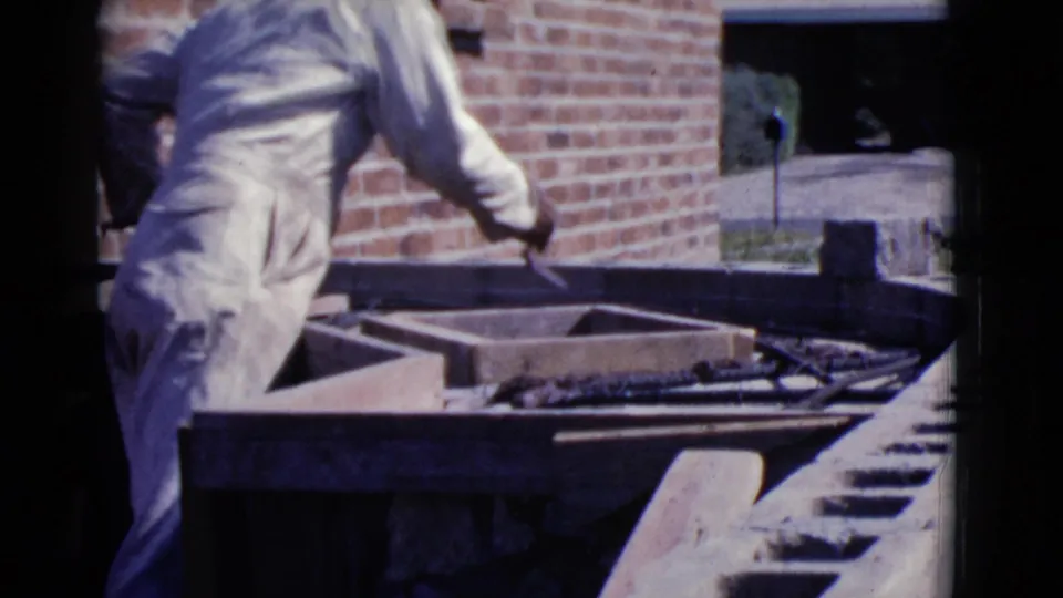 The worker stands at the masonry area, partly turned away, with a mortar tray, brickwork, and outdoor space visible in Cottonwood, Arizona.