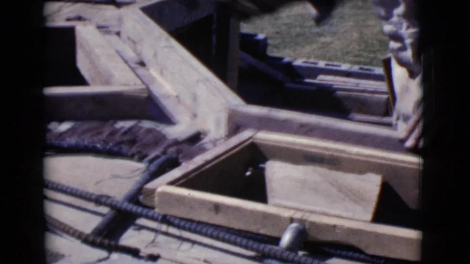 Wooden mold forms, rebar, and a worker's sleeve are seen in a close construction view from Cottonwood, Arizona, 1968.