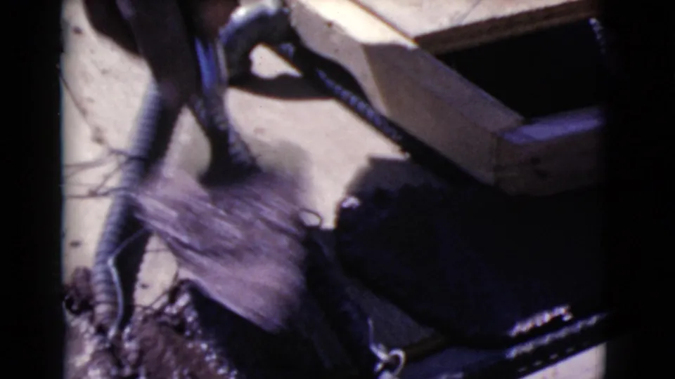 The frame shows a hammer and rebar beside wood forms, loose wire, and wet concrete or mortar on a 1968 construction surface.