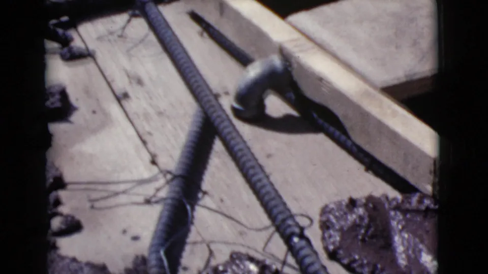 A close Cottonwood construction detail shows a hammer beside rebar, wire ties, wood form boards, and concrete block edges.