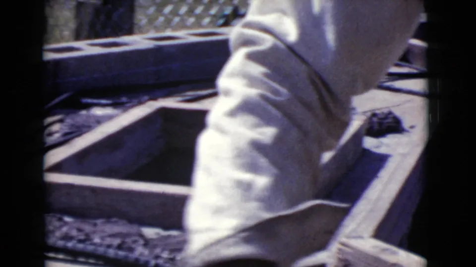 A man in a light long-sleeve shirt leans over a wooden construction frame in Cottonwood, Arizona, in 1968.