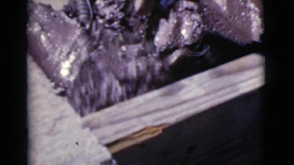 A close-up shows wet cement or concrete beside wooden formwork during the Cottonwood, Arizona well construction.