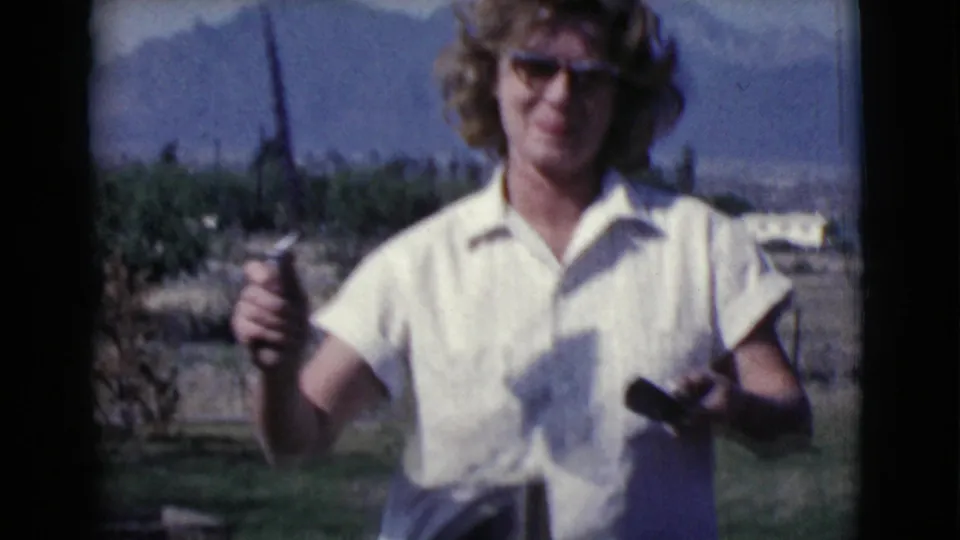 In the Cottonwood backyard scene, the woman holds a trowel or spatula while standing near the masonry work area.