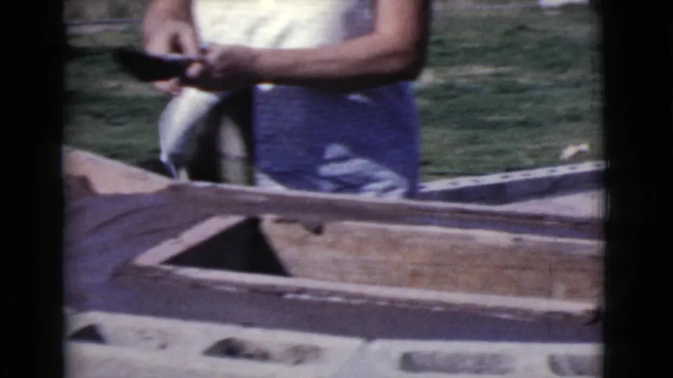 Cropped 8mm frame of a woman in a sleeveless top near wooden boards in a sunny Cottonwood yard.