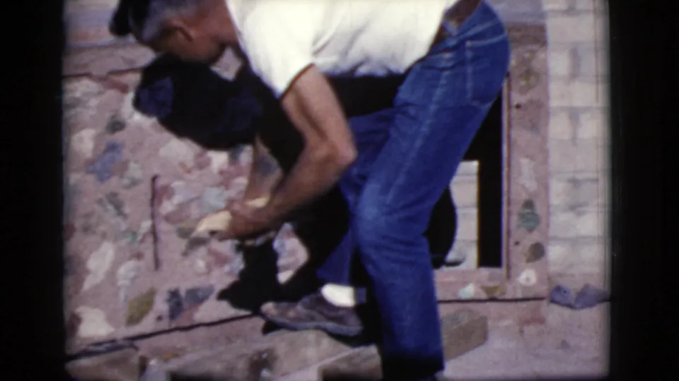 In Cottonwood, Arizona in 1968, a man works close to a brick wall or opening during an outdoor home project.