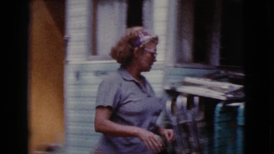 Older woman in profile near a vintage trailer and stacked outdoor gear, with 1968 Cottonwood, Arizona context from the clip metadata.