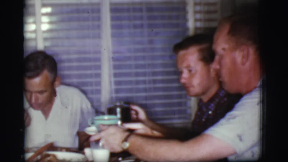 At the end of the 1968 Cottonwood, Arizona home-movie clip, three men sit around an indoor dinner table with coffee and milk visible.