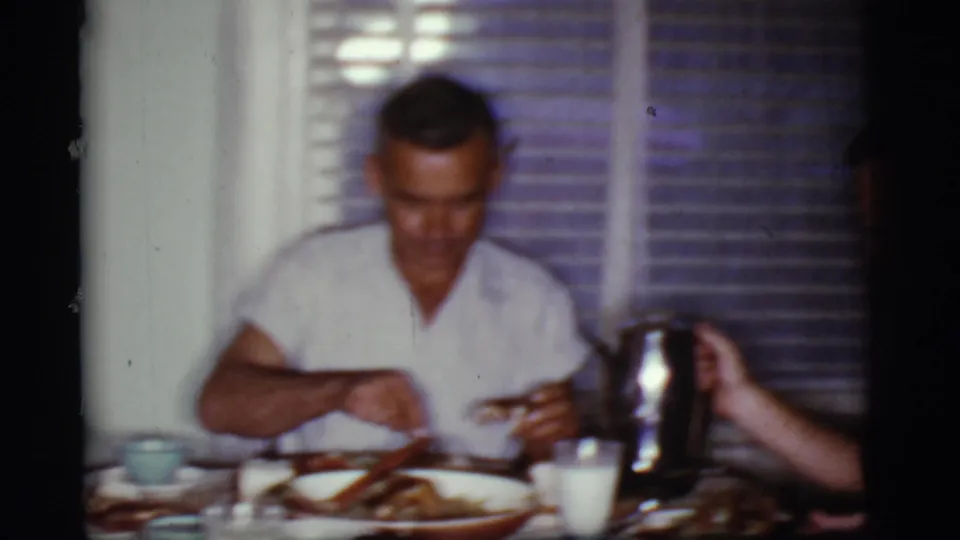 1968 Cottonwood, Arizona frame with a man eating breakfast as a metal coffee pot is held at the edge of the table.