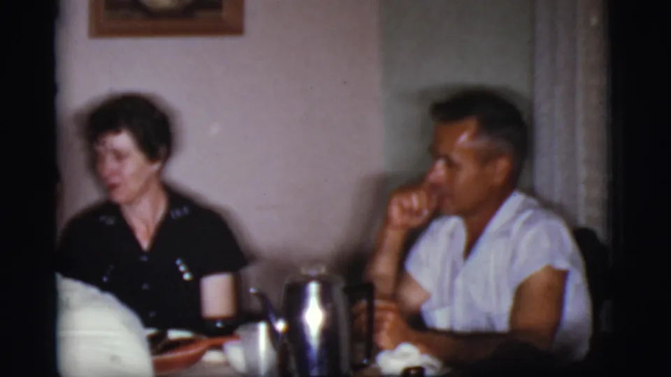 1968 Cottonwood, Arizona home interior showing two adults at a dining table with a silver coffee pot, cups, and soft 8mm blur.