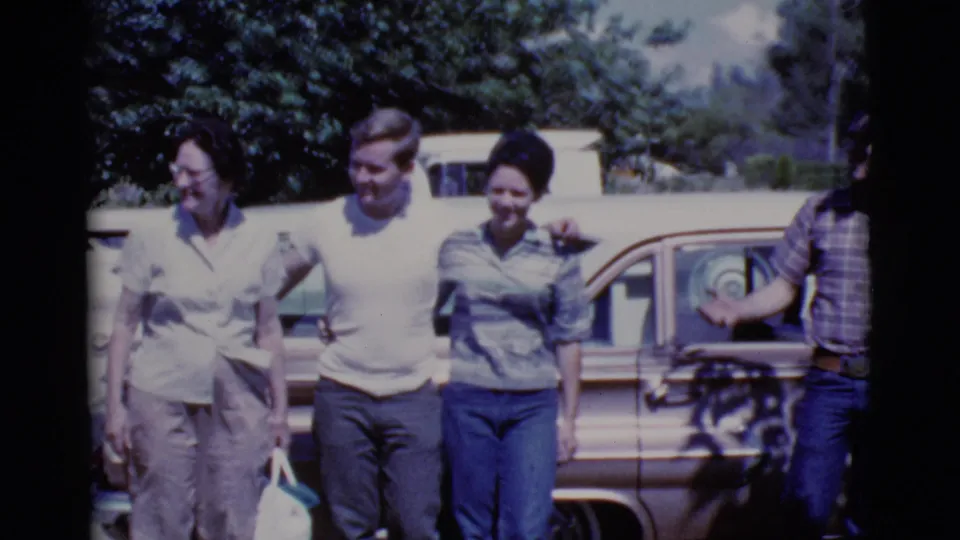 Four adults pose and smile beside a station wagon in 1968 Cottonwood, Arizona home-movie footage.