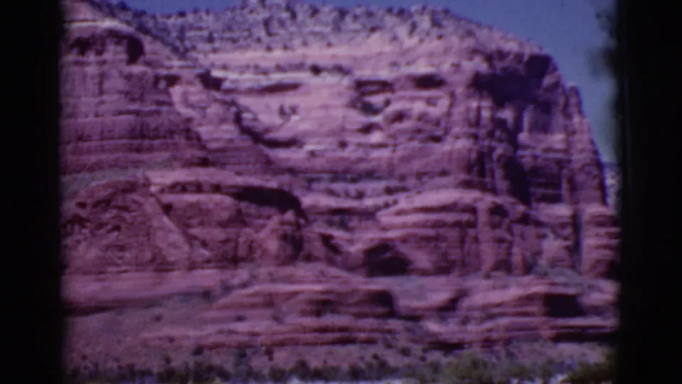 Red rock cliffs and sparse vegetation appear in faded 8mm color, consistent with the Cottonwood, Arizona clip metadata.