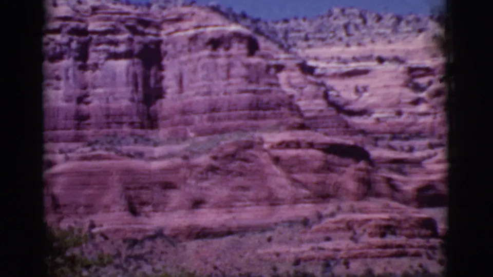 The pan continues across Cottonwood-area red rock, with eroded sandstone shelves, scrub at the base, and soft 8mm color shift.