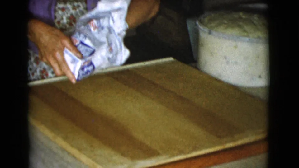 1968 Cottonwood, Arizona home kitchen frame showing flour being shaken from a paper bag onto a wooden board.