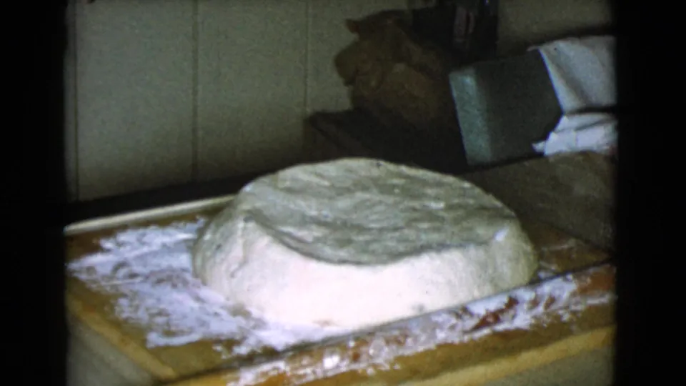 A large mound of bread dough sits on a floured wooden board inside the Cottonwood kitchen.