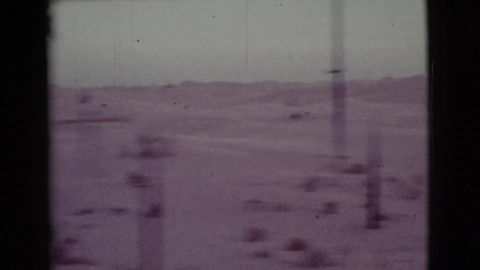 1968 Cottonwood, Arizona travel frame with desert flats, low hills, blurred brush, and a utility pole passing near the road.