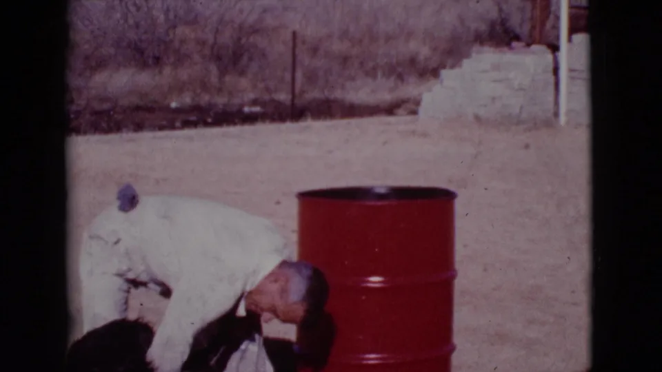 The final frame shows the light-uniformed man still crouched over the black dog in the dusty Cottonwood, Arizona setting.