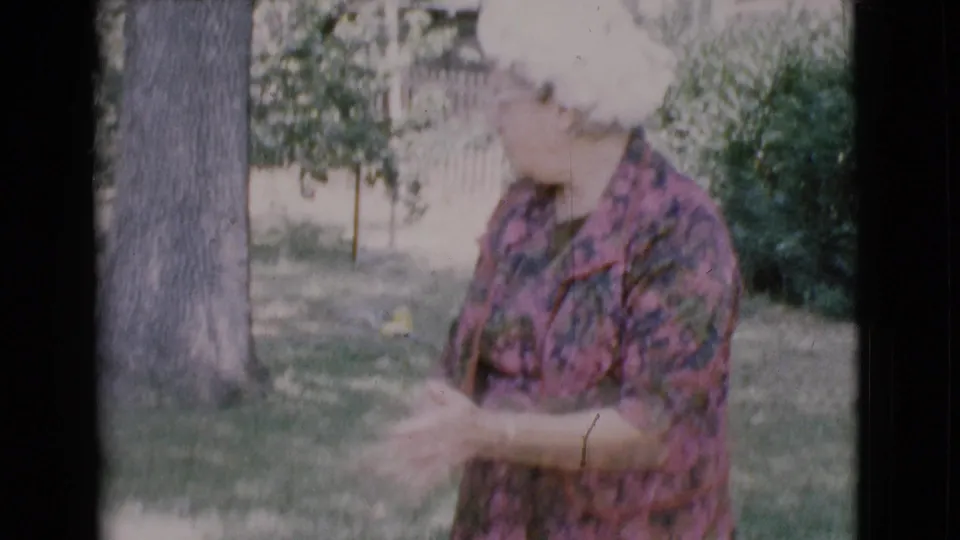 In 1968 Cottonwood home-movie footage, the woman gestures with her hands as if speaking to someone off camera.
