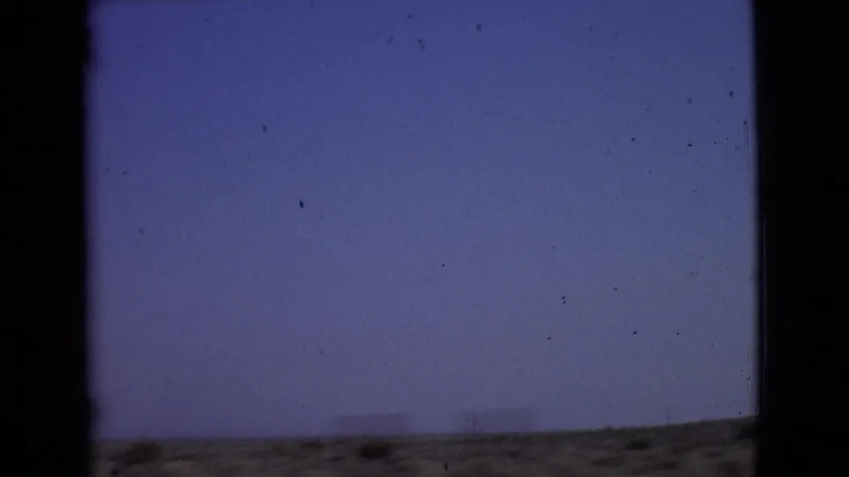 Final 1968 San Diego County road-view frame, showing a sparse desert horizon through the dark interior framing of a moving car.