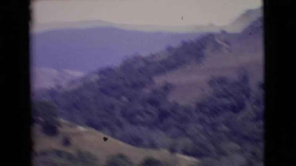 1968 San Diego County travel footage ending on a soft, blurred view of mountain slopes and hazy ridgelines.