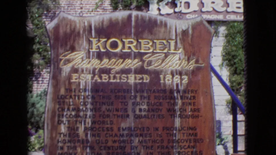 1968 San Diego County 8mm frame showing a weathered Korbel Champagne Cellars sign with established date and descriptive text.