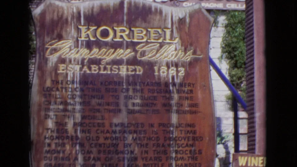 1968 San Diego County 8mm still showing the Korbel sign closer in frame, with lower text and partial wine-related storefront lettering.