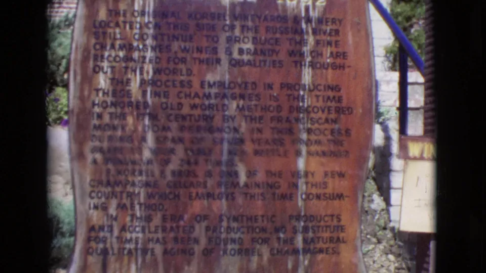 End frame of the 1968 8mm shot, showing the weathered winery history monument with faded text and a partial sign at the edge.