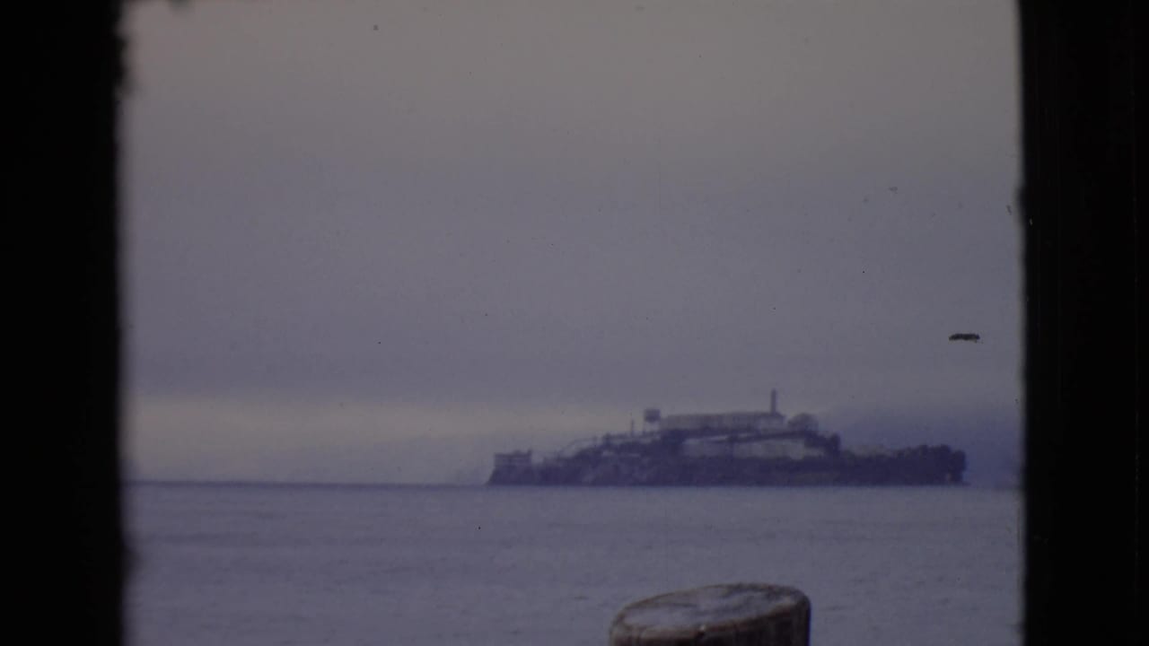Hazy distant ship on water seen through dark 8mm frame borders.