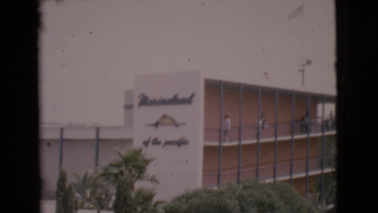 MarineLand sign and modern building seen through dark film-frame edges.
