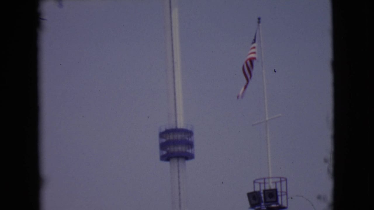 1968 San Diego 8mm frame showing a tall white pole with a blue deck and an American flag on a separate flagpole.