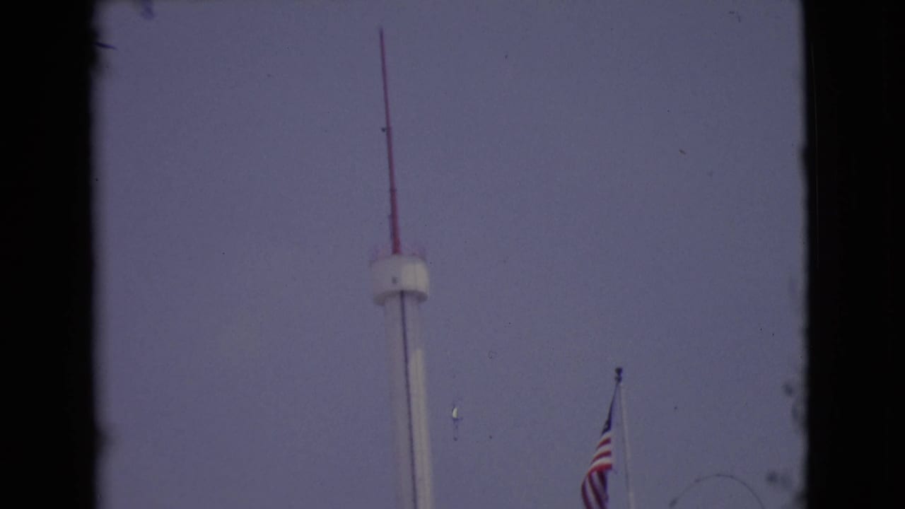 1968 San Diego frame showing the pole rising to a red antenna top, with the American flag lower at right.