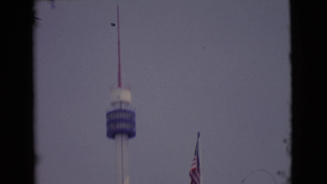 1968 San Diego-area 8mm frame with a blue tower deck, red antenna, and U.S. flag near the right edge.