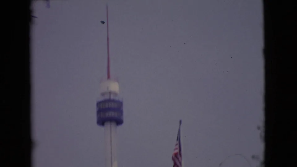 1968 San Diego-area 8mm frame with a blue tower deck, red antenna, and U.S. flag near the right edge.