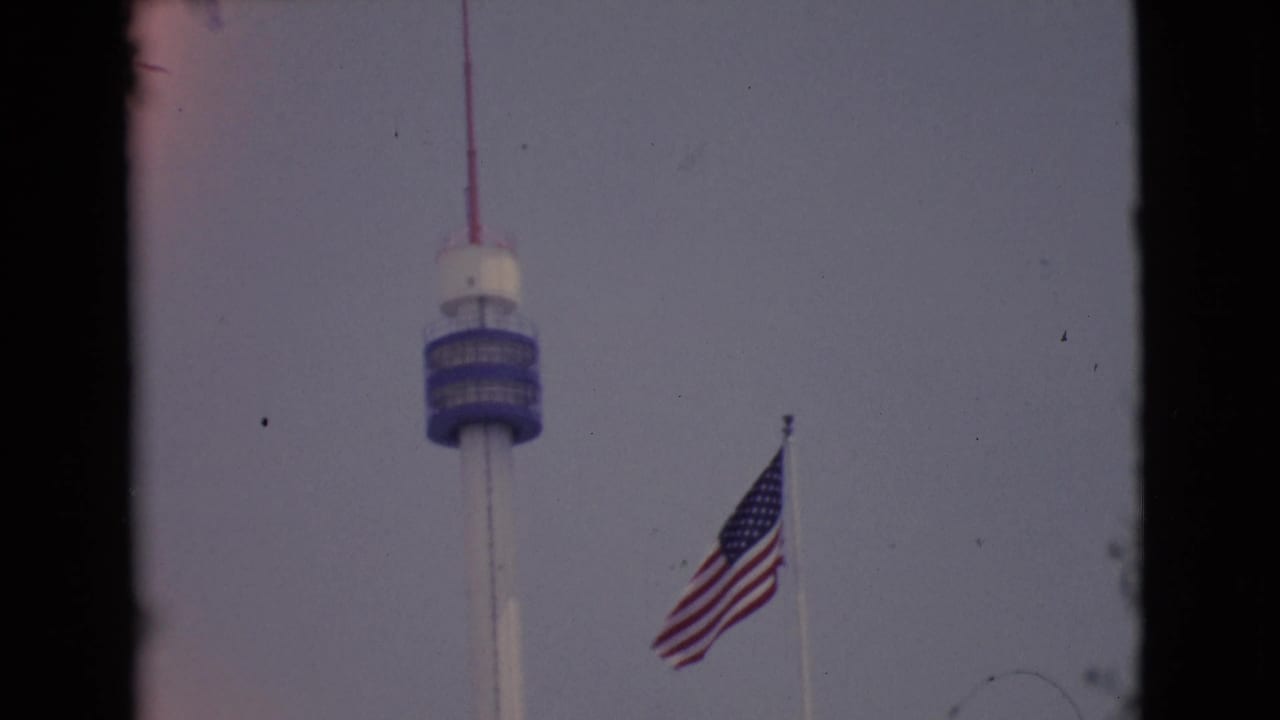 1968 San Diego County 8mm still showing the U.S. flag and tower with visible film wear and border edges.