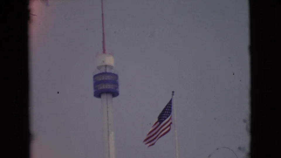 1968 San Diego County 8mm still showing the U.S. flag and tower with visible film wear and border edges.