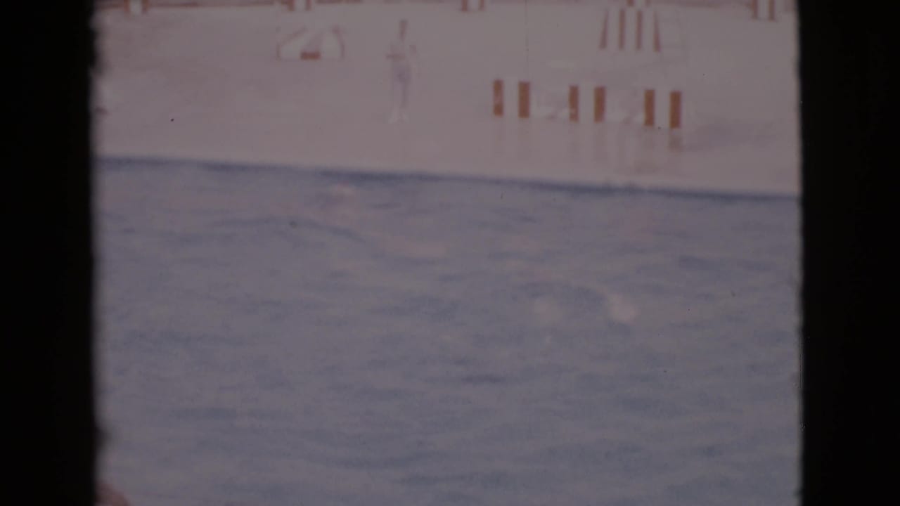 Wide pool view with a faint seal shape near the water and wall markings in the background.