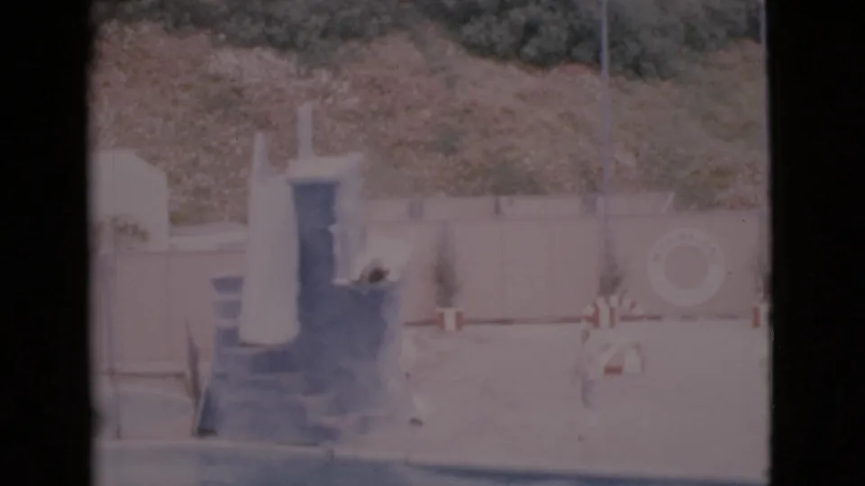 Visitor-shot 1968 San Diego County frame showing a seal at the platform area with staff nearby and water below.