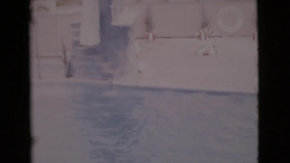 Faded 1968 San Diego County 8mm frame showing a marine park pool area with platform, wall, steps, and life preserver.