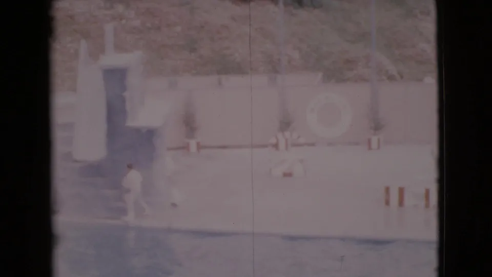 1968 San Diego County frame showing a trainer near the exhibit platform as the pool and safety ring remain visible.