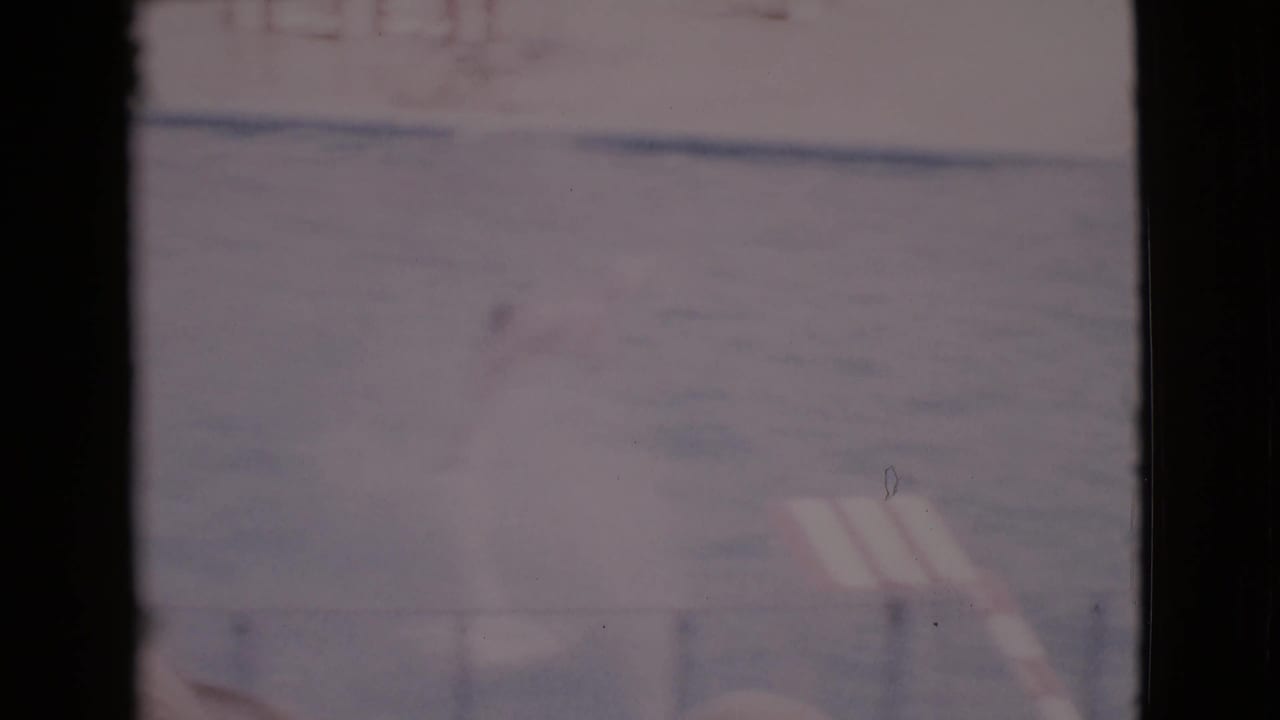 Mostly empty pool surface with railings and a striped shade element near the right edge.