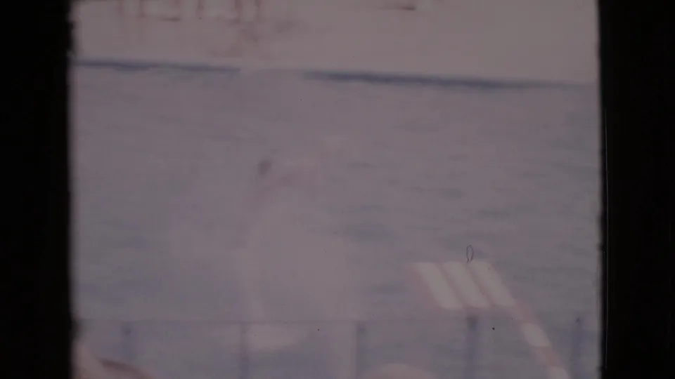 Faded 8mm frame of the marine show pool in San Diego County, with railings and a striped shade or awning visible at right.
