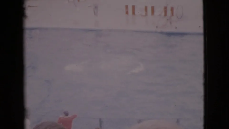 1968 San Diego County 8mm frame showing a pale blue aquarium pool, a small figure in red and striped poolside barriers.