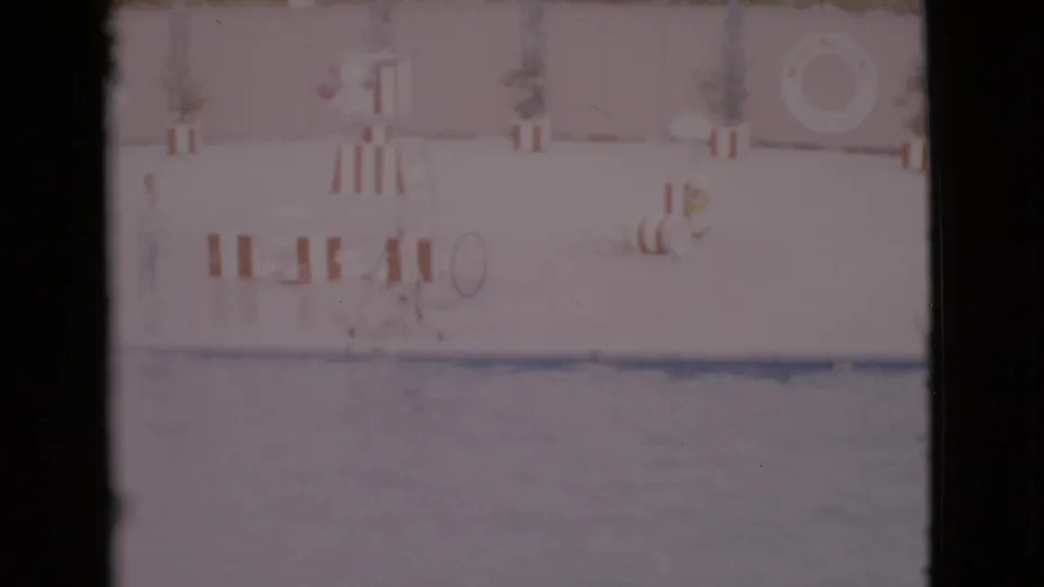 1968 San Diego County 8mm frame showing the pool, show wall, striped barriers, and life preserver at a marine attraction.