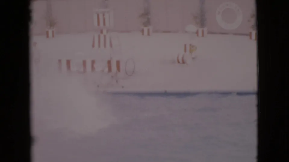 Faded 8mm frame showing the pool and aquatic park deck moments after the dolphin jump in 1968 San Diego County footage.