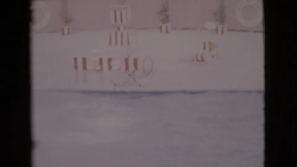 1968 8mm San Diego County footage showing a pale aquatic show pool with dolphins near the surface and striped poolside barriers.
