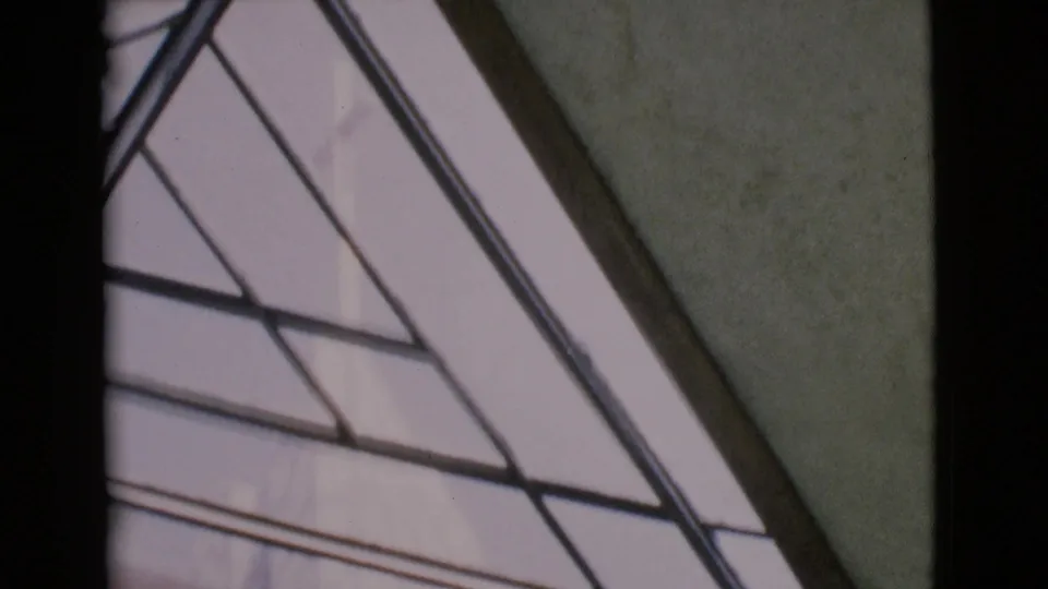 1968 San Diego County church ceiling detail with angled stained-glass panels, dark framing, and pale interior walls.