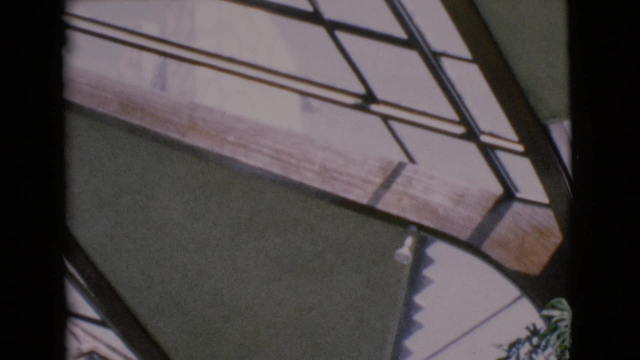 Dark vertical frame divides angled window panes and a shaded wall section.