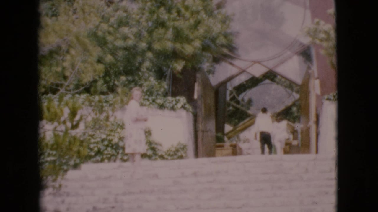 Wide stone staircase leading to a modern entrance with two people near the steps.