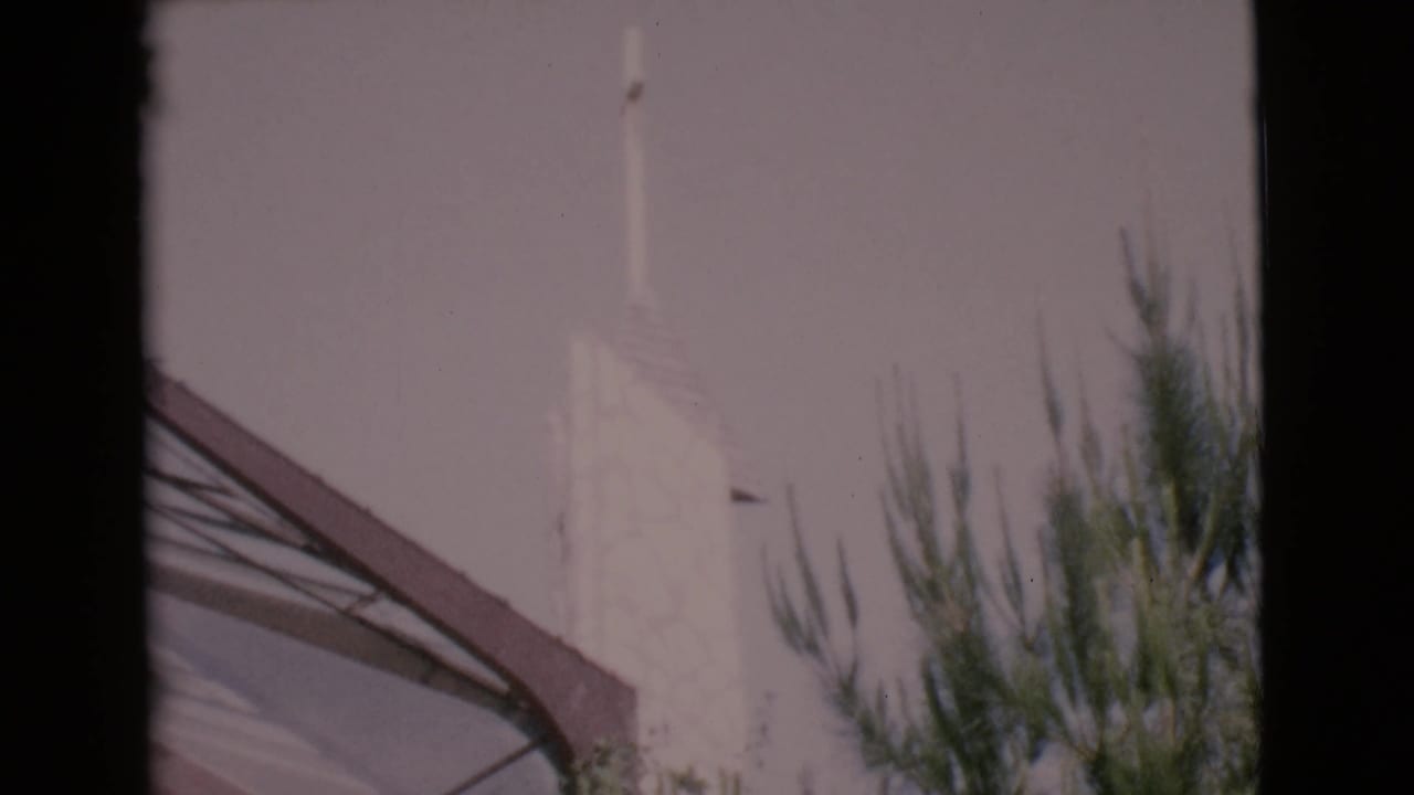 Steeple and roof edge partly obscured by a dark vertical window divider.